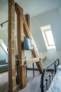 a room with a bed and a tv on a wooden wall at ARCHE Klasztor Wrocław in Wrocław
