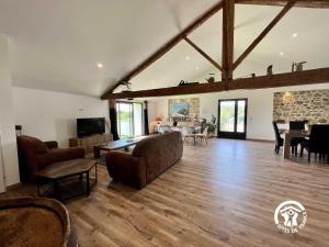 a large living room with a couch and a table at Le gite aux oliviers in La Redorte