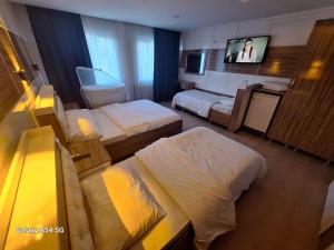 a hotel room with two beds and a flat screen tv at Dilmac Hotel in Gelibolu