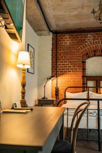 a room with a table and chairs and a brick wall at ARCHE Klasztor Wrocław in Wrocław