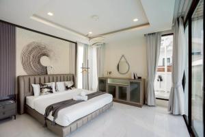 een slaapkamer met een groot bed en een raam bij Ralph Pool Villa Pattaya in Ban Huai Yai +92 foto's