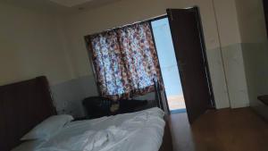 ein Schlafzimmer mit einem Bett und einem Fenster mit einem Vorhang in der Unterkunft streem View in Masuri