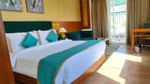 ムスーリーにあるstreem Viewの大きな白いベッドと青い枕のある寝室