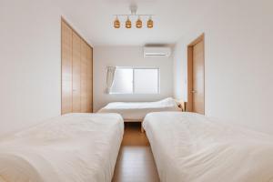 a bedroom with two beds and a window at 福宿美空 Fukuyado Misora in Fukuoka