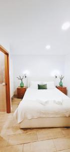 a white bedroom with a large white bed and wooden floors at Casa dos Sequeiras Port Rosé in Vila Nova de Gaia +18 photos