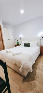 a bedroom with a large white bed with white pillows at Casa dos Sequeiras Port Rosé in Vila Nova de Gaia