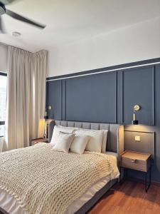 a bedroom with a large bed with a blue headboard at The Jelutong Trio, Spacious 3-Bedroom Luxury Stay in Shah Alam