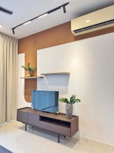 a living room with a flat screen tv on a wall at The Jelutong Trio, Spacious 3-Bedroom Luxury Stay in Shah Alam