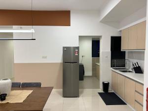 a kitchen with a refrigerator in the middle of it at The Jelutong Trio, Spacious 3-Bedroom Luxury Stay in Shah Alam +36 photos