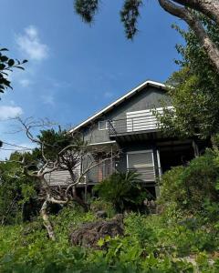 a house on top of a hill with trees at good wind 野風楼 in Yawatano