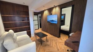 ein Wohnzimmer mit einem weißen Sofa und einem Fernseher in der Unterkunft 658 Suite in Eilat + 5 Fotos
