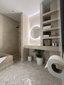 a bathroom with a tub and a sink and a mirror at Riad Manoury Marrakech - privates Boutique-Hotel für 6 in Marrakesh +25 photos