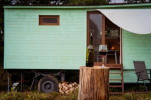 una botella de vino sobre un tronco con una copa en Maringotka Votavka, en Borovy 8 fotos más
