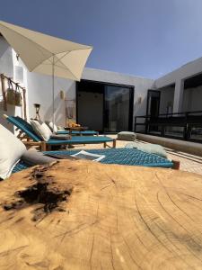 a patio with two lounge chairs and an umbrella at Riad Manoury Marrakech - privates Boutique-Hotel für 6 in Marrakesh