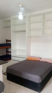 una camera da letto con un letto con mensole bianche e un soffitto di toninhas 300 mts mar a Ubatuba