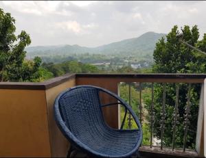 a blue wicker bench sitting on a balcony with a view at Sky View Kandy in Kandy