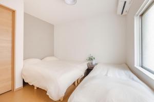 two beds in a room with a window at 福宿美空 Fukuyado Misora in Fukuoka