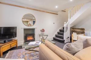a living room with a couch and a fireplace at Gatehouse Cottage in Cartmel in Rossendale