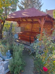a wooden gazebo with a bench in a garden at Apartment Ljupka in Pančevo +14 photos