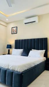 a large bed with a blue headboard in a room at Zameen Opal luxury Stay LDA Avenue Raiwind Rd in Lahore +57 photos