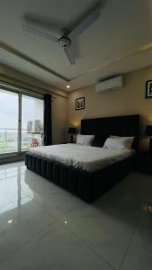 a bedroom with a large bed and a large window at Zameen Opal luxury Stay LDA Avenue Raiwind Rd in Lahore