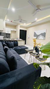 a living room with a blue couch and tables at Zameen Opal luxury Stay LDA Avenue Raiwind Rd in Lahore