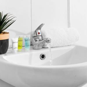 a bathroom sink with water running from a faucet at Modern Apartment - Pet Friendly - Fast Wi-Fi - Netflix - Wolverhampton 7PC in Wolverhampton