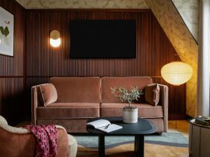 a living room with a couch and a table at Hotel Faubourg Galant Paris - Handwritten Collection in Paris