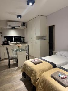 una camera con due letti e un tavolo e una cucina di DEPARTAMENTO en MICROCENTRO a Corrientes