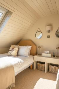 une chambre avec un lit dans un grenier dans l'établissement Luxury Skye Cottage Hot Tub & BBQ Lodge, à Lonmore