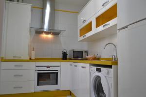 eine weiße Küche mit Waschmaschine in der Unterkunft Sunshine Patio de Fernando Colon in Córdoba