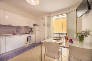 a kitchen with white cabinets and a table and chairs at Residence Tresor in Gallipoli
