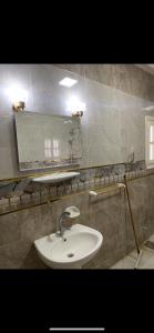 a bathroom with a sink and a mirror at Allam's Villa - Families only in Borg el Arab +4 photos