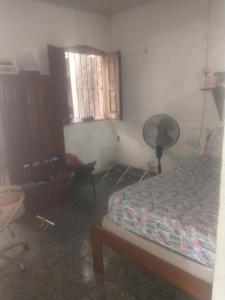 een slaapkamer met een bed, een ventilator en een raam bij Quartos para alugar na cop 30 in Ananindeua