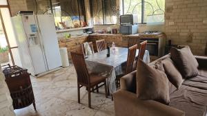 a living room with a table and a couch at The stone house by the river וילה ליד הנחל in Dafna