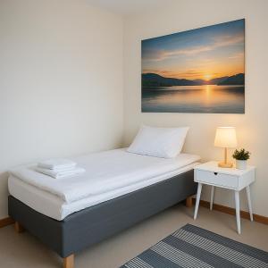 a bed in a room with a painting on the wall at Hotelli Vilho in Kotka