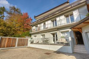 a large white house with a fence and a gate at Le Contempo in Veyrier-du-Lac