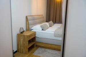 a small bedroom with a bed and a night stand at Residence Ali - garage included in Bjelašnica