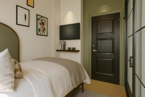 Un dormitorio con una cama y una puerta negra. en The Barker, en Londres