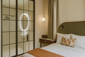 una habitación de hotel con una cama y un espejo en The Barker, en Londres