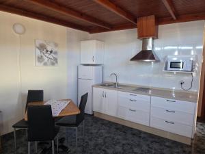 a kitchen with a sink and a table with chairs at apartamentos la villa in San Sebastián de la Gomera