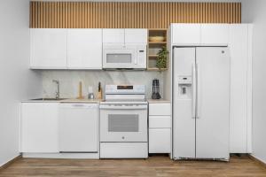een keuken met witte apparatuur en een witte koelkast bij Luxury 2BR Condo w/Pool, Rooftop, GYM @ Palm Beach in Palm-Eagle Beach