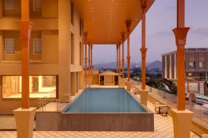 a building with a swimming pool on top of it at Lemon Tree Hotel, Mira Road, Mumbai in Sasupāda