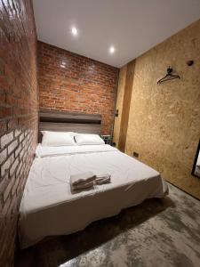 a bedroom with a brick wall and a bed at 九份玩具屋 in Ruifang