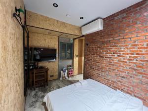 a bedroom with a brick wall and a bed at 九份玩具屋 in Ruifang +16 photos
