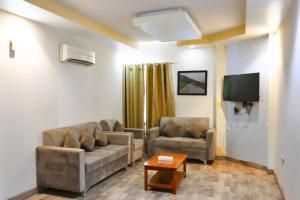 a living room with two couches and a tv at Muscat-Seeb 1BHK comfort apartment in Seeb