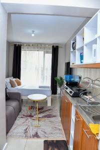 een keuken en woonkamer met een bank en een tafel bij Mex Homes Studio Apartment in Nairobi