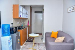 een woonkamer met een bank en een kleine keuken bij Mex Homes Studio Apartment in Nairobi +11 foto's