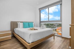 een slaapkamer met een groot bed met een groot raam bij 2BR2BA Condo w/ Pool & Gym – Walk to Palm Beach! in Palm-Eagle Beach +23 foto's