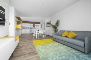 een woonkamer met een bank en een keuken bij Modern 2BA2BR Condo Pool + Gym Near Palm Beach in Palm-Eagle Beach